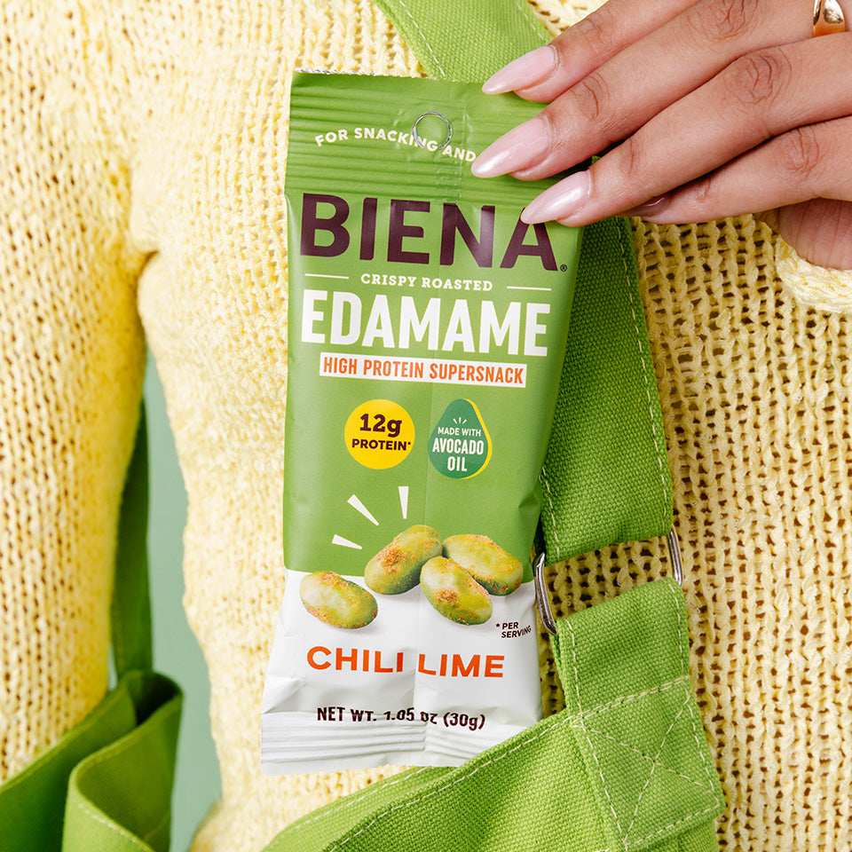 Bag of Biena Crispy Roasted Edamane Chili Lime Snack pulled out of a tote bag