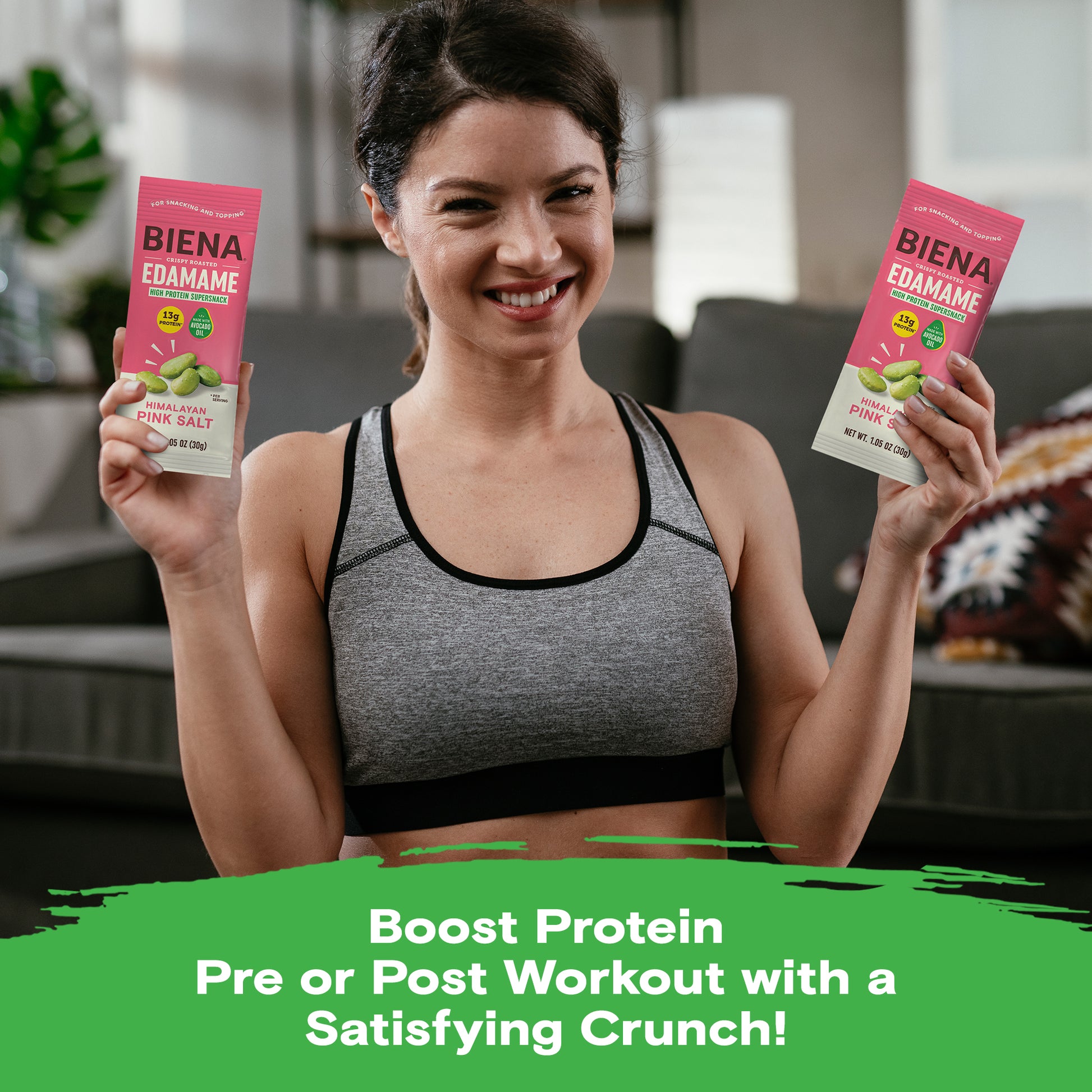 Woman holding two bags of Edamame Snacks as you boost protein pre or post workout with a satisfying crunch
